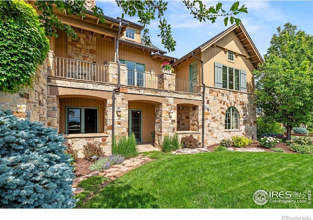 6619 Ridgeline Dr, Timnath, CO 80547 - view of front of home with a balcony, stone siding, and a front lawn