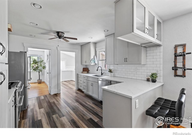834 Emery St, Longmont, CO 80501 - kitchen with appliances with stainless steel finishes, gray cabinets, decorative backsplash, ceiling fan, and plenty of natural light