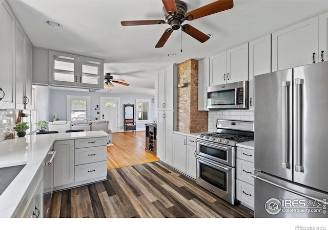 834 Emery St, Longmont, CO 80501 - kitchen featuring stainless steel appliances, a ceiling fan, open floor plan, light countertops, and backsplash