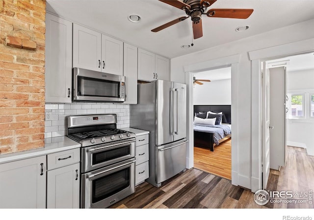 834 Emery St, Longmont, CO 80501 - kitchen featuring stainless steel appliances, a ceiling fan, dark wood-style floors, light countertops, and backsplash