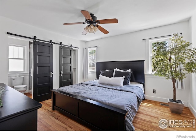 834 Emery St, Longmont, CO 80501 - bedroom featuring a barn door, wood finished floors, and ceiling fan