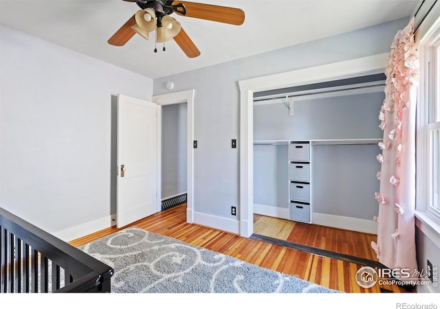 834 Emery St, Longmont, CO 80501 - unfurnished bedroom featuring wood finished floors, a closet, ceiling fan, and multiple windows