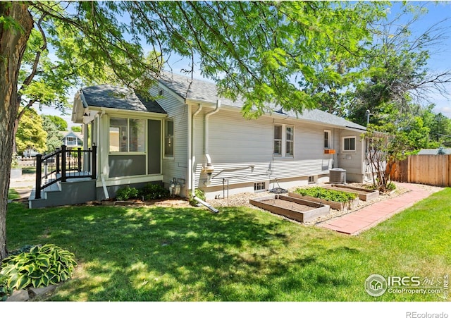 834 Emery St, Longmont, CO 80501 - view of front of property featuring a vegetable garden, a sunroom, and roof with shingles