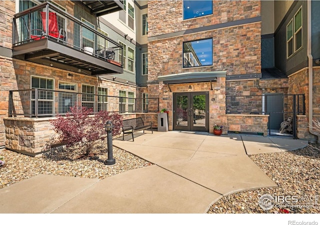 13598 Via Varra Unit 412, Broomfield, CO 80020 - property entrance featuring french doors, stone siding, and a balcony