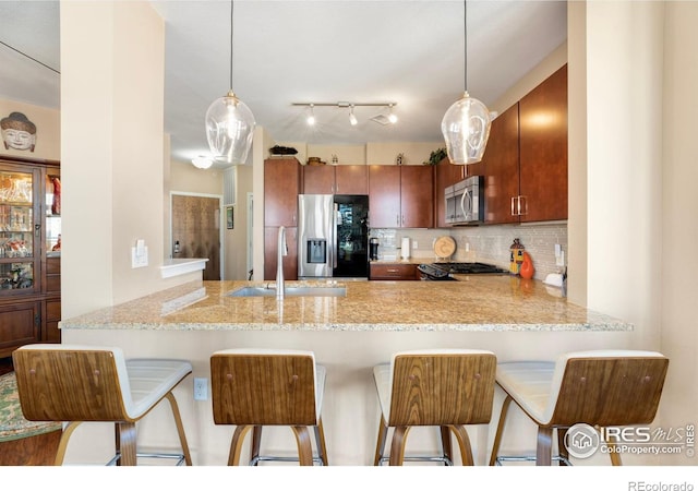 13598 Via Varra Unit 412, Broomfield, CO 80020 - kitchen with appliances with stainless steel finishes, a peninsula, tasteful backsplash, and pendant lighting