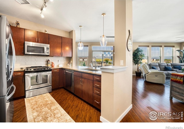 13598 Via Varra Unit 412, Broomfield, CO 80020 - kitchen featuring appliances with stainless steel finishes, healthy amount of natural light, open floor plan, and tasteful backsplash