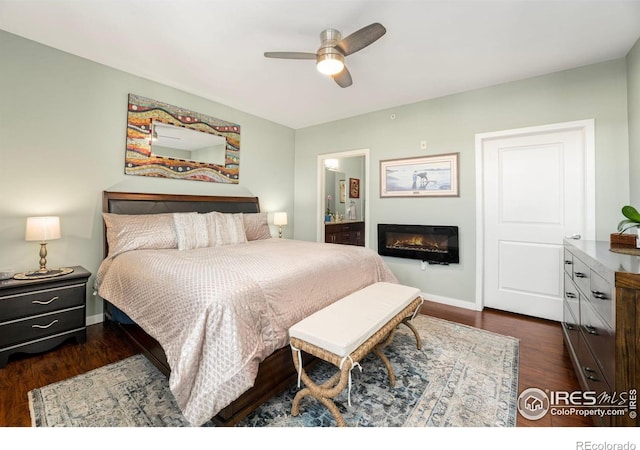 13598 Via Varra Unit 412, Broomfield, CO 80020 - bedroom featuring a glass covered fireplace, dark wood finished floors, connected bathroom, and ceiling fan