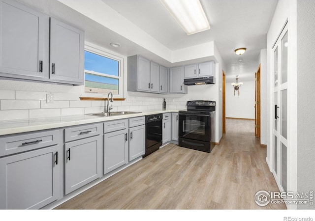 3233 Baldwin Ave, Evans, CO 80620 - kitchen featuring black appliances, gray cabinetry, backsplash, light wood-style floors, and light countertops