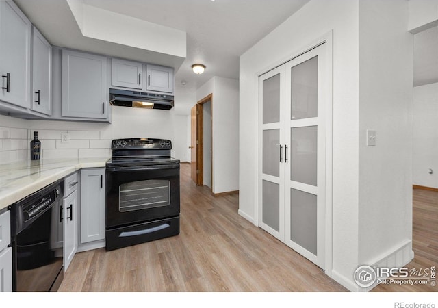 3233 Baldwin Ave, Evans, CO 80620 - kitchen with black appliances, under cabinet range hood, gray cabinetry, and light wood-style floors