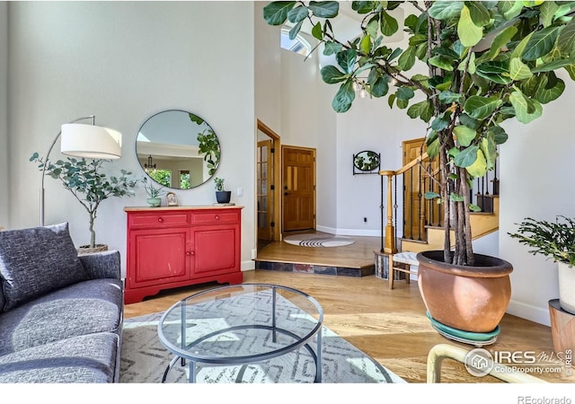 6366 Umber Cir, Arvada, CO 80403 - living area featuring wood finished floors, a high ceiling, and stairway