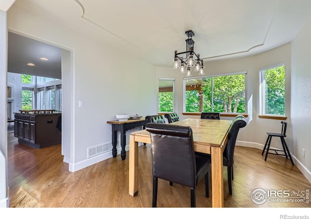 6366 Umber Cir, Arvada, CO 80403 - dining space featuring healthy amount of natural light, light wood-style floors, and a chandelier