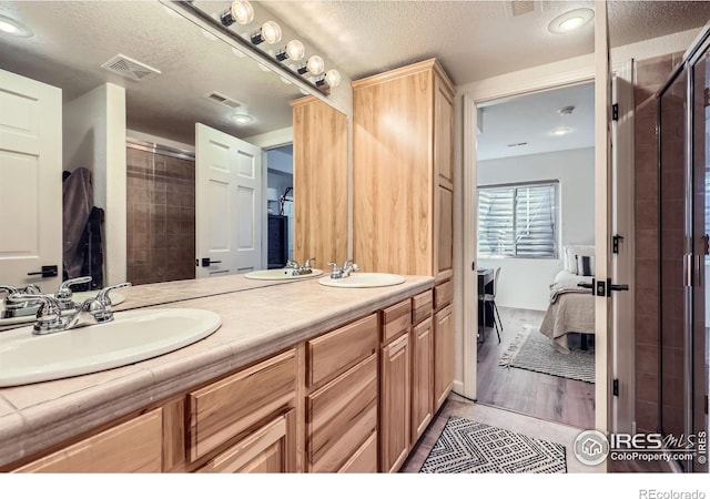 6366 Umber Cir, Arvada, CO 80403 - full bath featuring ensuite bath, double vanity, a textured ceiling, a shower stall, and tile patterned floors