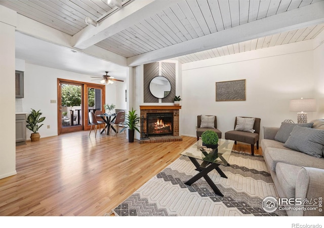 1220 Solstice Ln, Fort Collins, CO 80525 - living room with a brick fireplace, light wood-type flooring, a wooden ceiling with exposed beams, and a ceiling fan