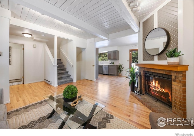 1220 Solstice Ln, Fort Collins, CO 80525 - living room featuring light wood-type flooring, a fireplace, baseboard heating, stairs, and a wooden ceiling with exposed beams