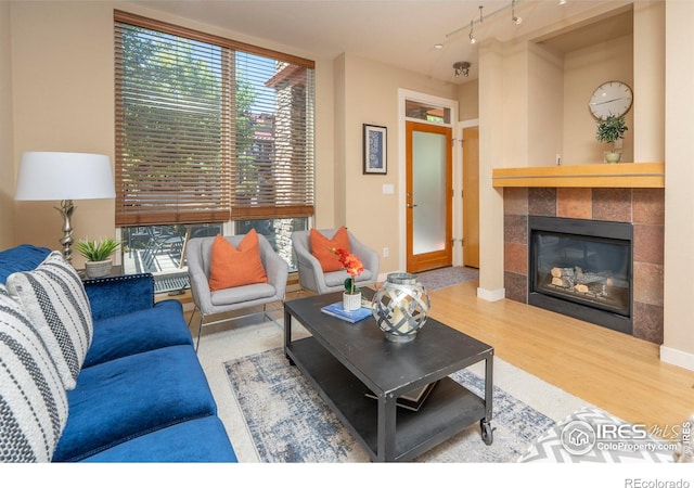 5060 Pierre St Unit E, Boulder, CO 80304 - living room featuring a tiled fireplace, wood finished floors, and rail lighting