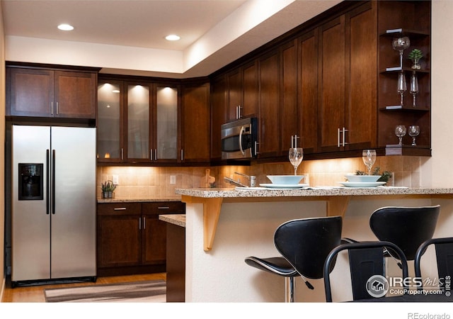 5060 Pierre St Unit E, Boulder, CO 80304 - kitchen featuring stainless steel appliances, open shelves, dark brown cabinets, glass insert cabinets, and decorative backsplash