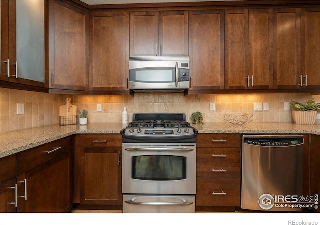 5060 Pierre St Unit E, Boulder, CO 80304 - kitchen with appliances with stainless steel finishes, light stone counters, and backsplash