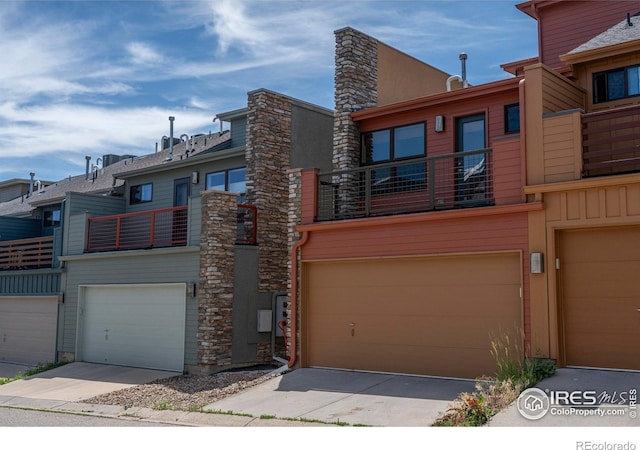 5060 Pierre St Unit E, Boulder, CO 80304 - view of front of house featuring a garage, a balcony, and stone siding
