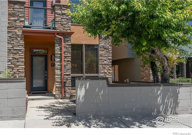 5060 Pierre St Unit E, Boulder, CO 80304 - entrance to property with a balcony, stone siding, and stucco siding