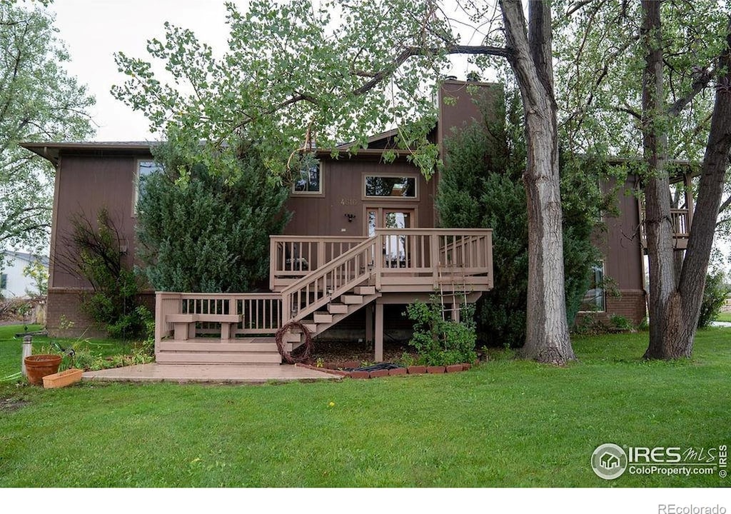 4616 Lonetree Dr, Loveland, CO 80537 - rear view of property featuring a wooden deck, a lawn, and stairway
