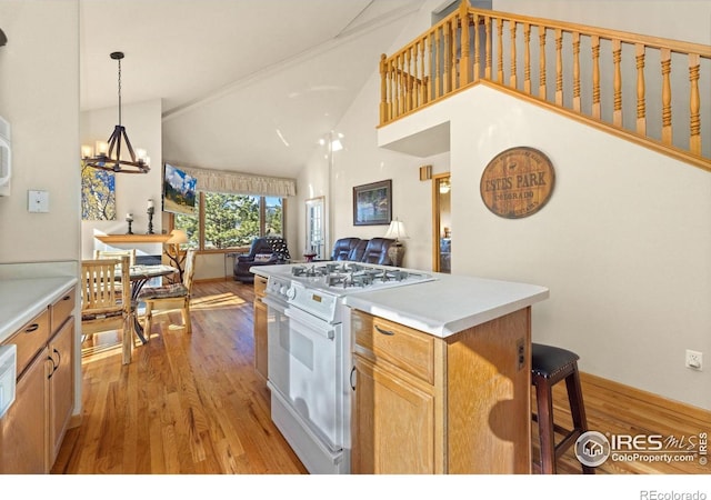 1437 Raven Cir Unit A, Estes Park, CO 80517 - kitchen featuring white gas range, open floor plan, light wood-style flooring, a chandelier, and high vaulted ceiling