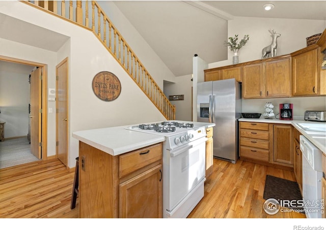 1437 Raven Cir Unit A, Estes Park, CO 80517 - kitchen with white appliances, light wood finished floors, a kitchen island, light countertops, and brown cabinets
