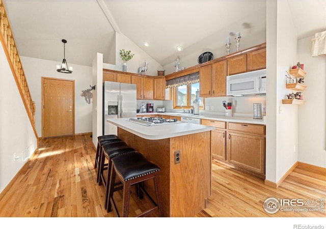 1437 Raven Cir Unit A, Estes Park, CO 80517 - kitchen featuring white appliances, light countertops, light wood finished floors, a center island, and a kitchen breakfast bar