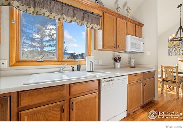 1437 Raven Cir Unit A, Estes Park, CO 80517 - kitchen featuring white appliances, light wood finished floors, light countertops, a chandelier, and brown cabinetry