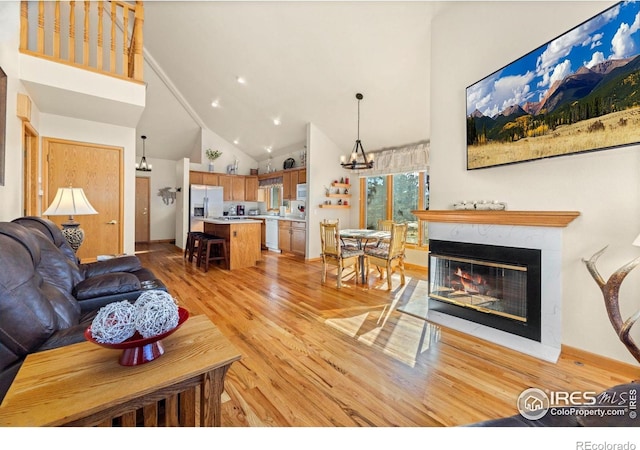 1437 Raven Cir Unit A, Estes Park, CO 80517 - living area featuring high vaulted ceiling, light wood-style floors, a chandelier, a multi sided fireplace, and recessed lighting
