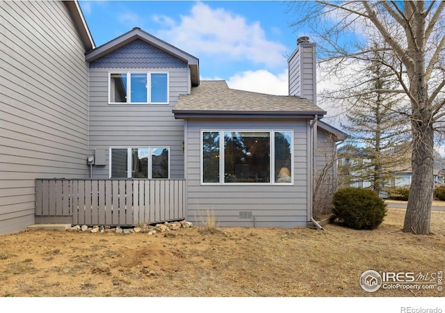 1437 Raven Cir Unit A, Estes Park, CO 80517 - rear view of house with a shingled roof and a chimney