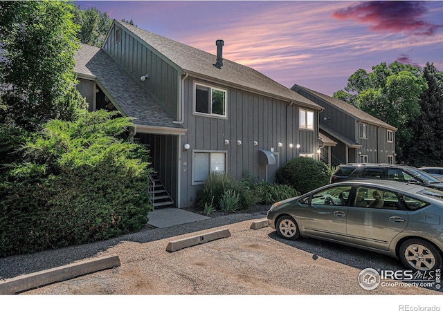 705 E Drake Rd Unit 45, Fort Collins, CO 80525 - view of front facade with roof with shingles, board and batten siding, stairway, and uncovered parking