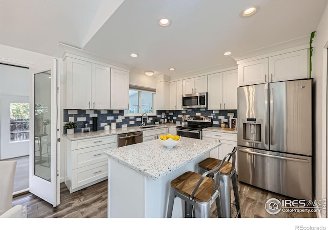 1287 Doric Dr, Lafayette, CO 80026 - kitchen with appliances with stainless steel finishes, white cabinetry, dark wood-type flooring, tasteful backsplash, and recessed lighting