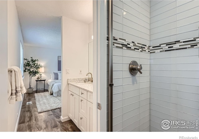 1287 Doric Dr, Lafayette, CO 80026 - full bath featuring wood finished floors, a shower stall, ensuite bath, vanity, and a textured ceiling