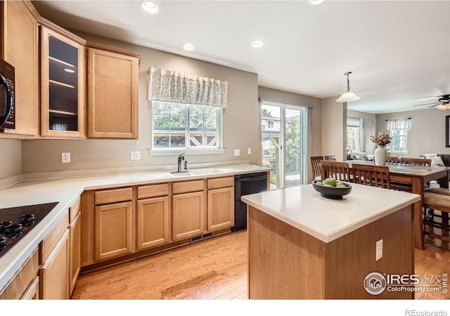 13065 Tamarac Pl, Thornton, CO 80602 - kitchen featuring black appliances, light wood-type flooring, a center island, glass insert cabinets, and open floor plan