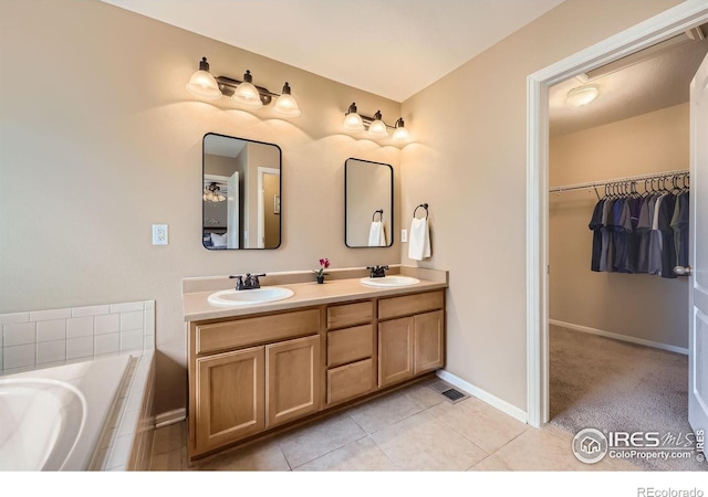13065 Tamarac Pl, Thornton, CO 80602 - full bathroom with double vanity, a bath, a walk in closet, and tile patterned flooring