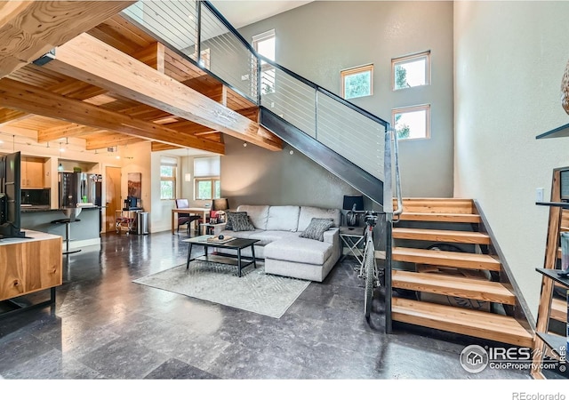 801 Confidence Dr Unit 16, Longmont, CO 80504 - living room featuring stairs, a towering ceiling, and a wood ceiling with exposed beams