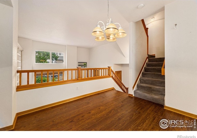 3686 Oakwood Dr, Longmont, CO 80503 - unfurnished room with a chandelier, wood finished floors, stairway, and a smoke detector