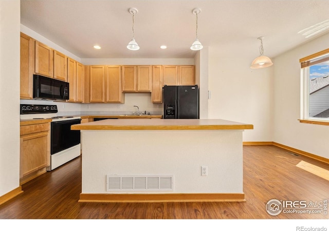 3686 Oakwood Dr, Longmont, CO 80503 - kitchen with black appliances, dark wood finished floors, light countertops, a kitchen island, and hanging light fixtures