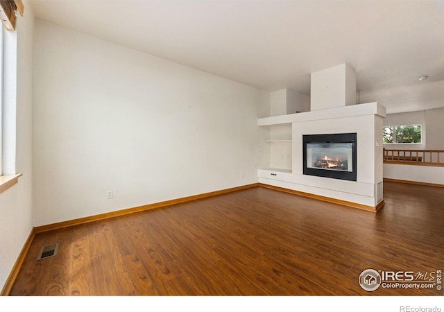 3686 Oakwood Dr, Longmont, CO 80503 - unfurnished living room with wood finished floors and a glass covered fireplace