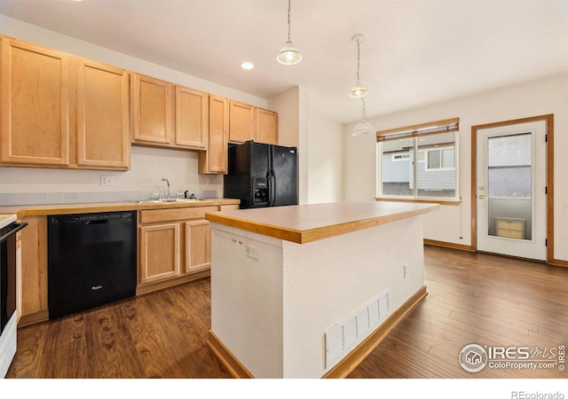 3686 Oakwood Dr, Longmont, CO 80503 - kitchen with black appliances, light brown cabinetry, dark wood-style flooring, light countertops, and pendant lighting