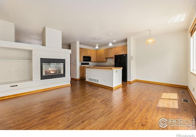 3686 Oakwood Dr, Longmont, CO 80503 - kitchen with black appliances, open floor plan, wood finished floors, and a center island