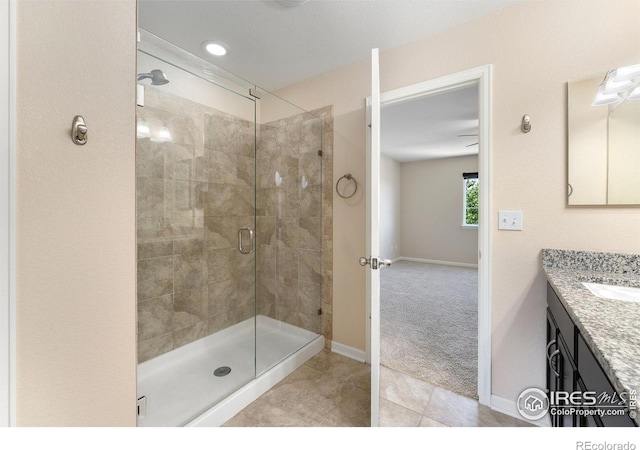 5049 S Ukraine St, Aurora, CO 80015 - bathroom featuring a shower stall, vanity, and tile patterned floors