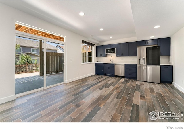 5049 S Ukraine St, Aurora, CO 80015 - kitchen with appliances with stainless steel finishes, light countertops, dark wood finished floors, and recessed lighting