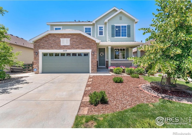5049 S Ukraine St, Aurora, CO 80015 - view of front of property with a porch, stone siding, an attached garage, and concrete driveway