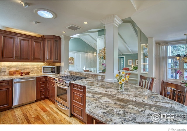 4471 Wellington Rd, Boulder, CO 80301 - kitchen featuring stainless steel appliances, ornate columns, tasteful backsplash, light stone countertops, and light wood finished floors