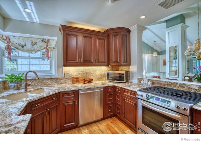 4471 Wellington Rd, Boulder, CO 80301 - kitchen featuring appliances with stainless steel finishes, decorative backsplash, light stone counters, light wood-style floors, and lofted ceiling