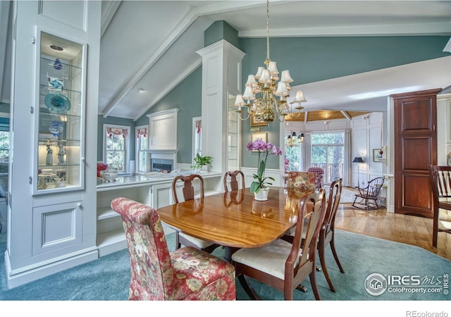 4471 Wellington Rd, Boulder, CO 80301 - dining area featuring a chandelier, wood finished floors, plenty of natural light, a fireplace, and beam ceiling
