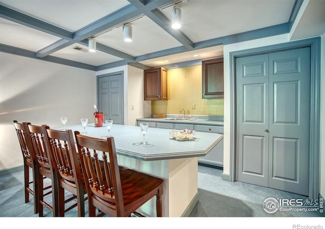 4471 Wellington Rd, Boulder, CO 80301 - kitchen featuring light colored carpet, a kitchen bar, light countertops, and beam ceiling