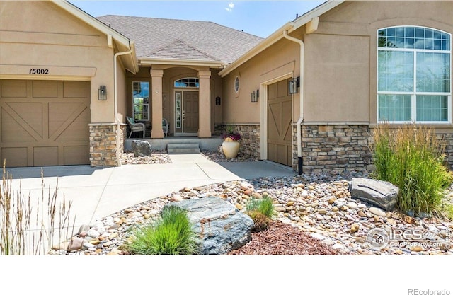 15002 Cosmos Way, Broomfield, CO 80023 - property entrance featuring stone siding, a garage, stucco siding, and concrete driveway