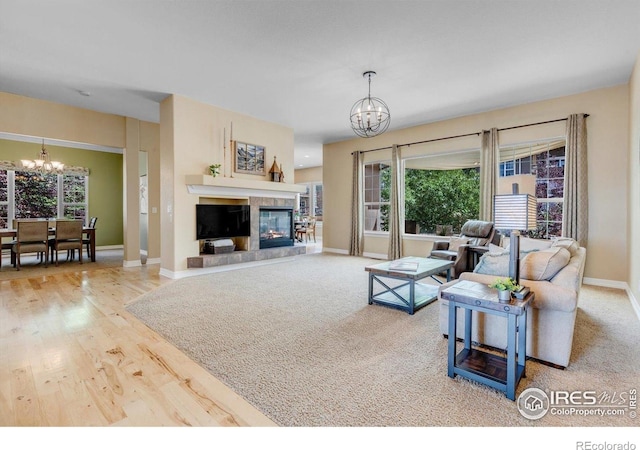 15002 Cosmos Way, Broomfield, CO 80023 - living room featuring a chandelier, a tile fireplace, plenty of natural light, and wood finished floors
